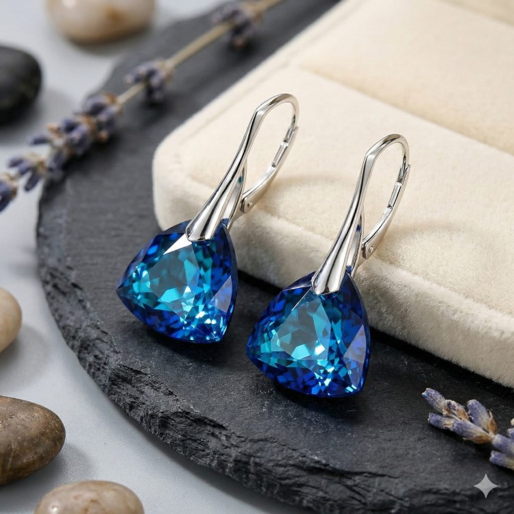 Kolczyki z kryształami Bermuda Blue ułożone na ciemniejszym tle